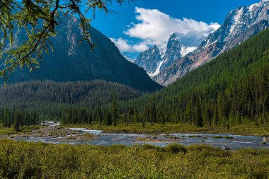 Ufukta tepeleri ve kaya tepeleri olan göl, dağlarda yürüyüş ve tırmanma, mavi suyun üzerindeki taş uçurum.