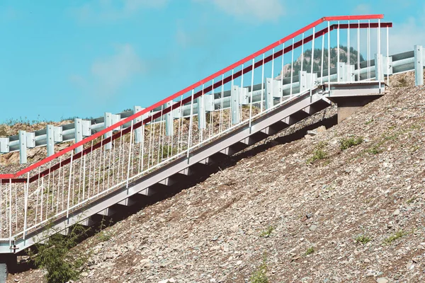 metal stairs with railings on mountain slope, moving up to reach goal