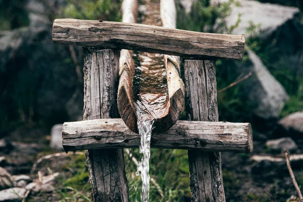 Akıntıdan gelen ahşap su kemeri, sulama ve su teslimi ahşap yalaktan, sıcak bir günde susuzluğu giderir.