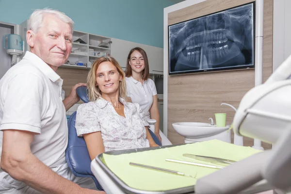 Patient dentist and assistant in the treatment room — Stock fotografie