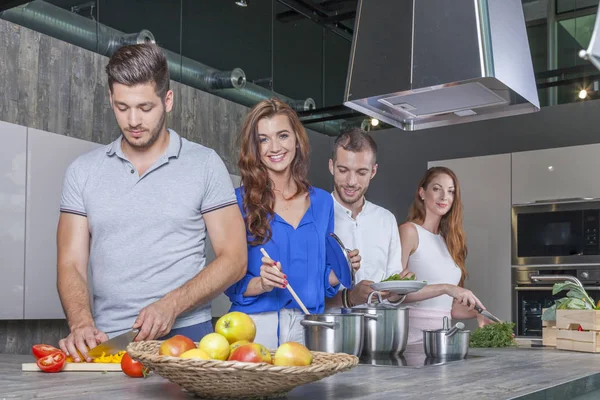 Vier vrienden met een kookfeestje in de keuken — Stockfoto