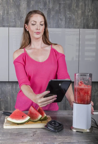 Frau in der Küche mit Tablet und Mixer — Stockfoto