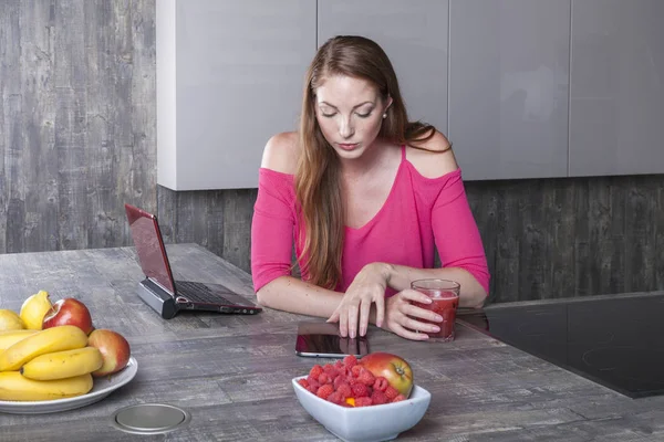 Frau in der Küche arbeitet mit Tablet — Stockfoto