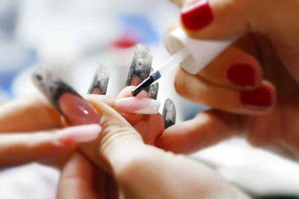 Woman having a nail manicure and polish in beauty salon