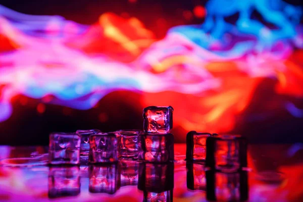 Ледяные кубики на красочном фоне — стоковое фото