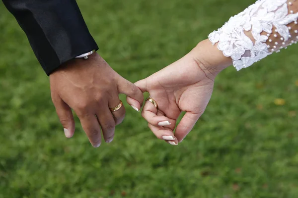 Mãos de noiva e noivo com os dedos unidos — Fotografia de Stock