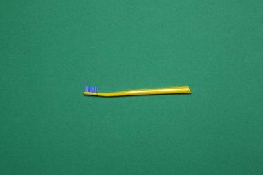 Yeşil arkaplanda sarı diş fırçası