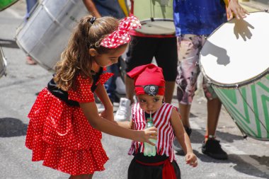 Children in carnival costumes drinking water
