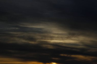 Bulutların arasında batan güneşle altın öğleden sonra