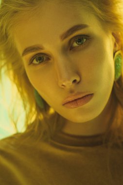 Stüdyoda moda fotoğraf çekimi. Güzel kadın model. Sarı leopar elbisesi. Stüdyo rafları ve flaşlar. Sarı ve yeşil arkaplan.