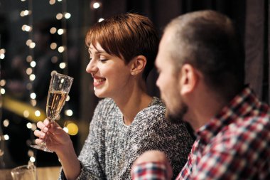 Arkadaşların evde yemek masasında tatil partisi veriyor. Noel 'i kutlayalım. İnsanlar yiyor, şampanya içiyor, konuşuyor ve gülüyor..