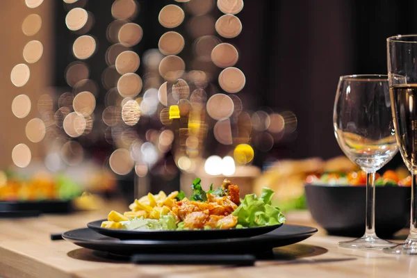 Cenário festivo da mesa. Comida e bebidas, pratos e copos. Luzes e velas nocturnas. Eva de Ano Novo . — Fotografia de Stock