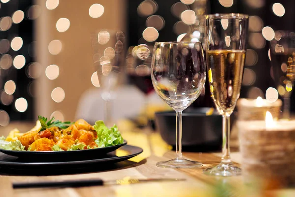 Cenário festivo da mesa. Comida e bebidas, pratos e copos. Luzes e velas nocturnas. Eva de Ano Novo . — Fotografia de Stock