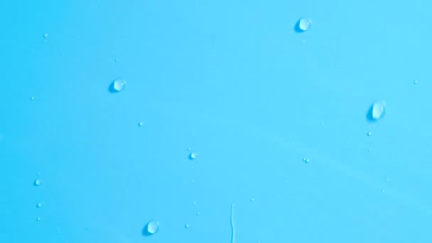 Gotas de agua fluyen lentamente por la pared azul . — Vídeos de Stock