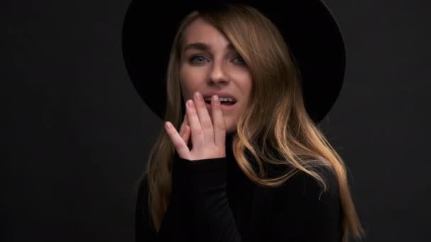 Portrait of a beautiful young blonde woman in a black hat with fields and a sweater. A sensual emotional woman. — Stock Video