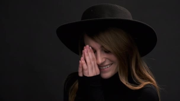 Portrait of a beautiful young blonde woman in a black hat with fields and a sweater. A sensual emotional woman. — Stock Video