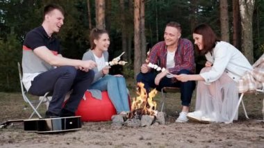 Bir grup arkadaş bir orman kampında dinleniyor. Erkekler ve kadınlar şenlik ateşinde marşmelov hazırlıyorlar. Doğada bir parti.