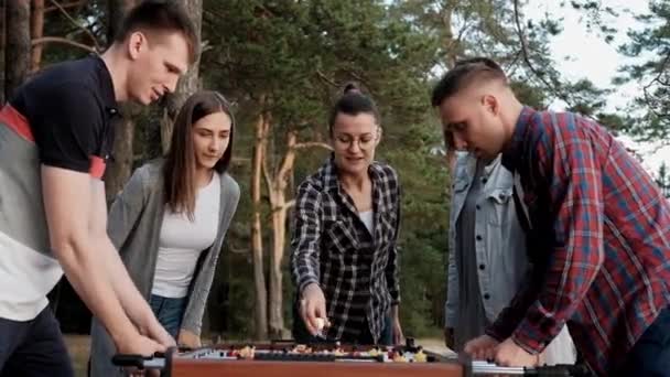 Arkadaşlar masa futbolu oynar ya da dışarıda tekmelerler. Oyuncular ve taraftarlar zafere seviniyor. — Stok video