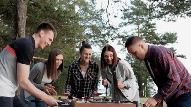 Los amigos juegan al futbolín o patean al aire libre. Jugadores y fans se regocijan en la victoria . — Vídeo de stock