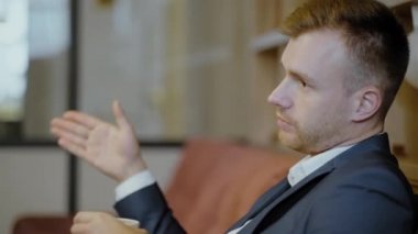 Takım elbiseli iki adam bir restoranda oturuyor. Bir iş toplantısı. Erkekler kahve içer ve konuşur..