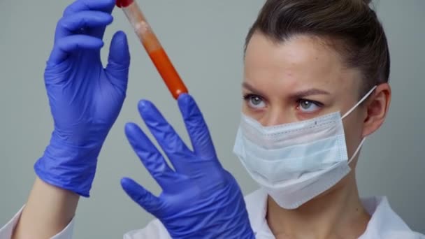 Esami del sangue. Una operaia medica donna tiene una provetta con sangue di paciets . — Video Stock