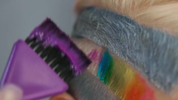 Cabeleireiro colorista coloca tinta no cabelo com uma escova. Um corte de cabelo curto, templo raspado, ornamento no cabelo . — Vídeo de Stock