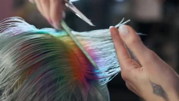 La peluquera corta cabello teñido cliente femenino con tijeras. Un corto corte de pelo pixie y las sienes afeitadas  . — Vídeo de stock