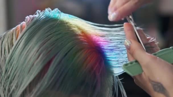 Kadeřník stříhá obarvenou klientku na vlasy nůžkami. Krátký pixie sestřih a oholené spánky . — Stock video