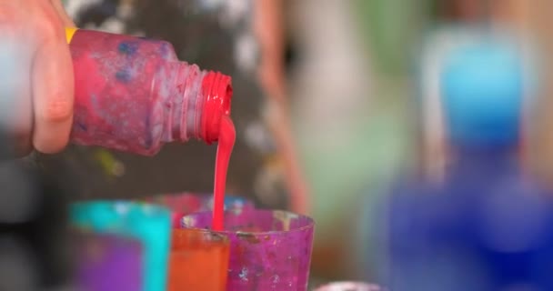 Una artista femenina prepara y amasa pinturas para el dibujo. Diferentes colores brillantes. Primer plano de las manos . — Vídeos de Stock