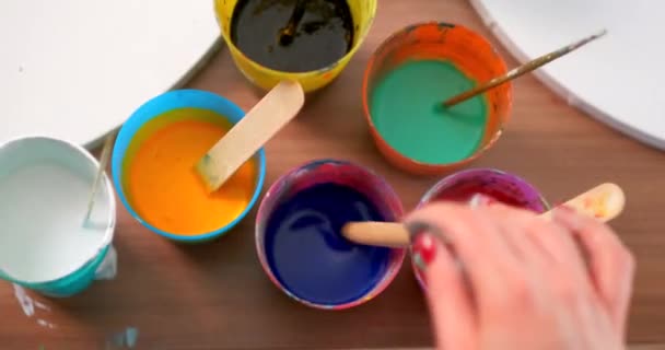 Женщина-художник готовит и наносит на колени краски для рисования. Различные яркие цвета. Крупный план рук . — стоковое видео