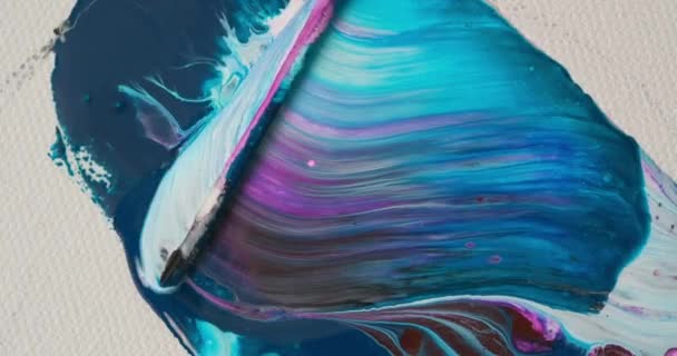 A woman artist paints an abstract painting with oil. Fluid drawing with a wand. Bright paint on a white canvas. — Stock Video