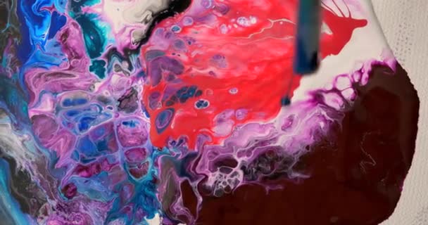 Una artista femenina dibuja una abstracción de fluidos soplando a través de un tubo . — Vídeo de stock