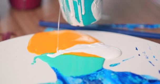 En kvinnlig konstnär målar en abstrakt målning med olja. Vätskeritning med trollspö. Ljus färg på en vit duk. — Stockvideo