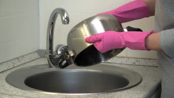 Žena v gumových rukavicích myje kovový hrnec houbou z tuku. — Stock video
