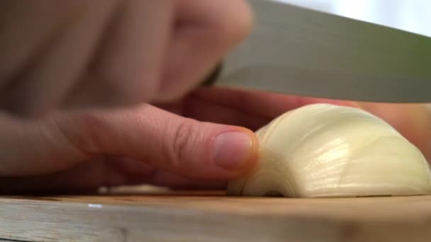 Egy háziasszony otthon főz a konyhában. Levágom a hagymát a vágódeszkáról.. — Stock videók