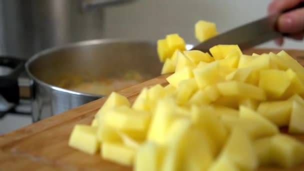 Escovar e cortar batatas. Cozinhar sopa de repolho russo. Uma mulher corta vegetais em uma tábua de corte. Cozinhar em casa . — Vídeo de Stock