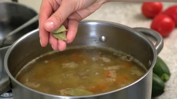 Додайте листок до каструлі. Готувати російський суп з капусти. На дошці ріжуть овочі.. — стокове відео
