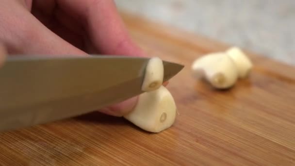A female cook cuts garlic on a cutting board. Cooking Russian cabbage soup. A woman cuts vegetables on a cutting board. — Stock Video