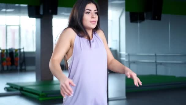 En ung idrottskvinna i sportkläder värmer upp och stretchar. Förberedelser för att börja träna. — Stockvideo