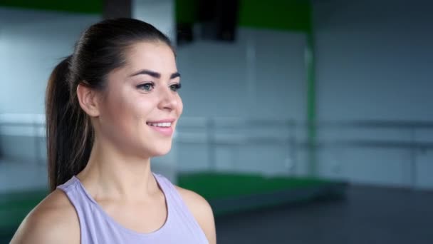 Una hermosa joven morena atlética en trenes de ropa deportiva con mancuernas en el gimnasio . — Vídeo de stock