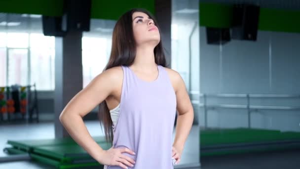 En ung idrottskvinna i sportkläder värmer upp och stretchar. Förberedelser för att börja träna. — Stockvideo