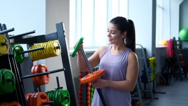 Bonita esportiva jovem morena em roupas esportivas no ginásio . — Vídeo de Stock