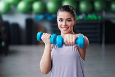 Spor giyim trenlerinde spor salonunda güzel, esmer bir kadın..