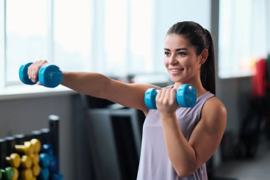 Spor giyim trenlerinde spor salonunda güzel, esmer bir kadın..