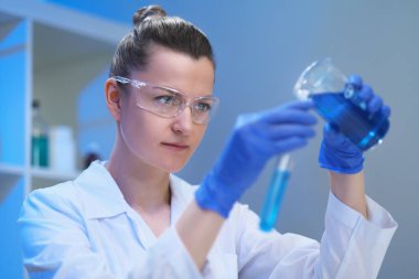 Kadın bir tıp bilimci laboratuarda çalışıyor. Spiker deneyler yapıyor, virüsten müzayedeyi geliştiriyor. Coronavirus covid-19.