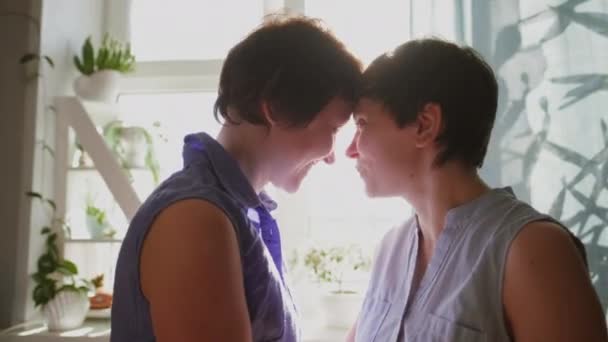 Evde iki genç kadın sarılıp öpüşüyor. Günlük giysiler. Lezbiyen çift, homoseksüel ilişkiler, eşcinsel aşk.. — Stok video