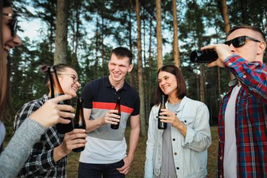 Bir grup arkadaş doğada dinlenir ve dinlenir. İnsanlar hamburger yer, bira içer, iletişim kurar ve güler..