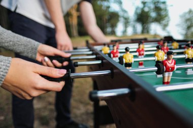 Arkadaşlar masa futbolu oynar ya da dışarıda tekmelerler. Oyuncular ve taraftarlar zafere seviniyor.