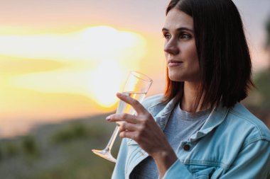 Ormanda günbatımında kısa saçlı, çekici, kızıl saçlı bir kadın..