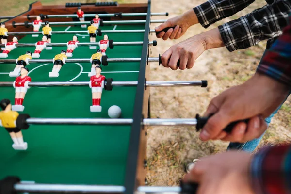 Arkadaşlar masa futbolu oynar ya da dışarıda tekmelerler. Oyuncular ve taraftarlar zafere seviniyor.